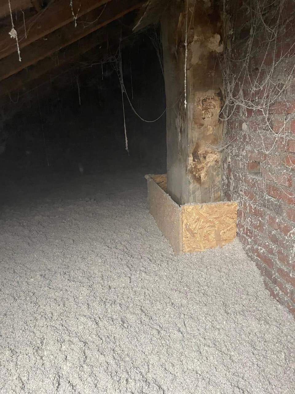 Coffrage en panneau de bois autour d'un poteau de charpente, combles isolés par soufflage